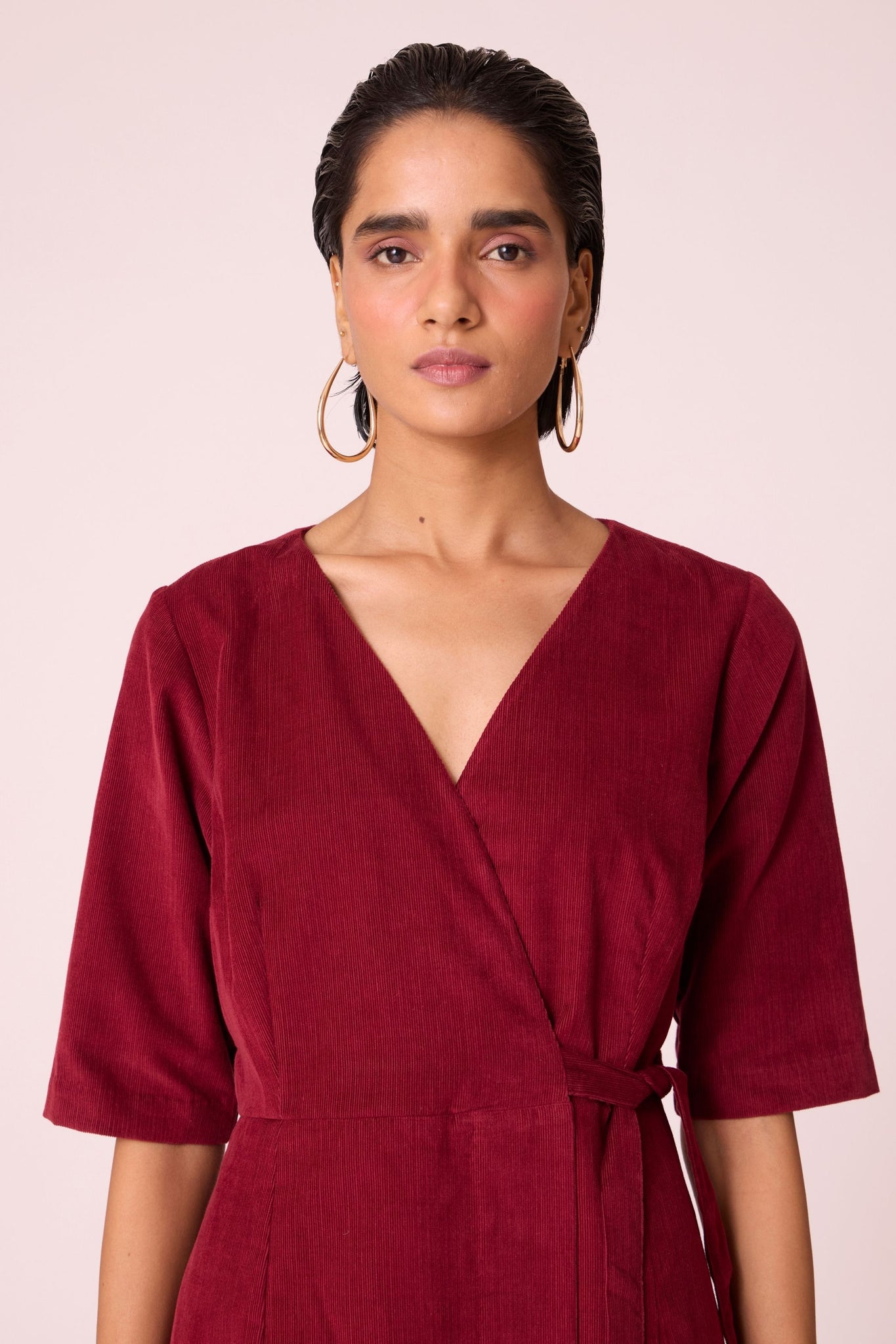 Cherry needlecord wrap dress with elbow-length sleeves, self-tie waist, and in-seam pockets.
