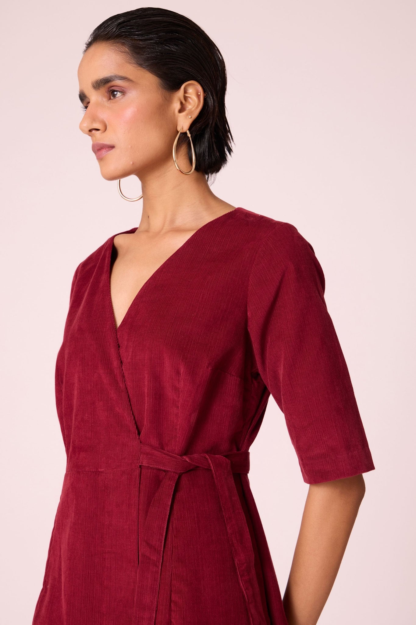 Cherry needlecord wrap dress with elbow-length sleeves, self-tie waist, and in-seam pockets.
