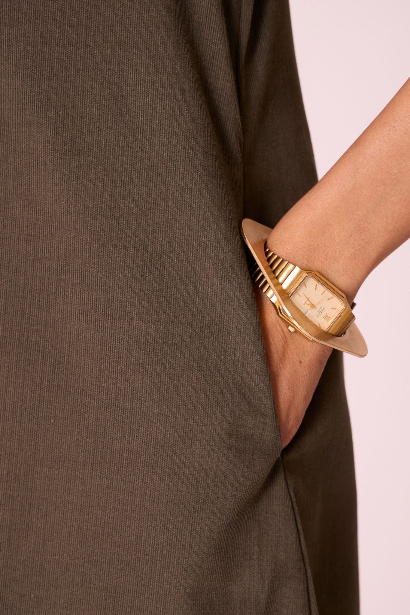 Olive needlecord A-line dress with drop shoulder, hand-embroidered cuff, deep scoop neckline, and in-seam pockets.