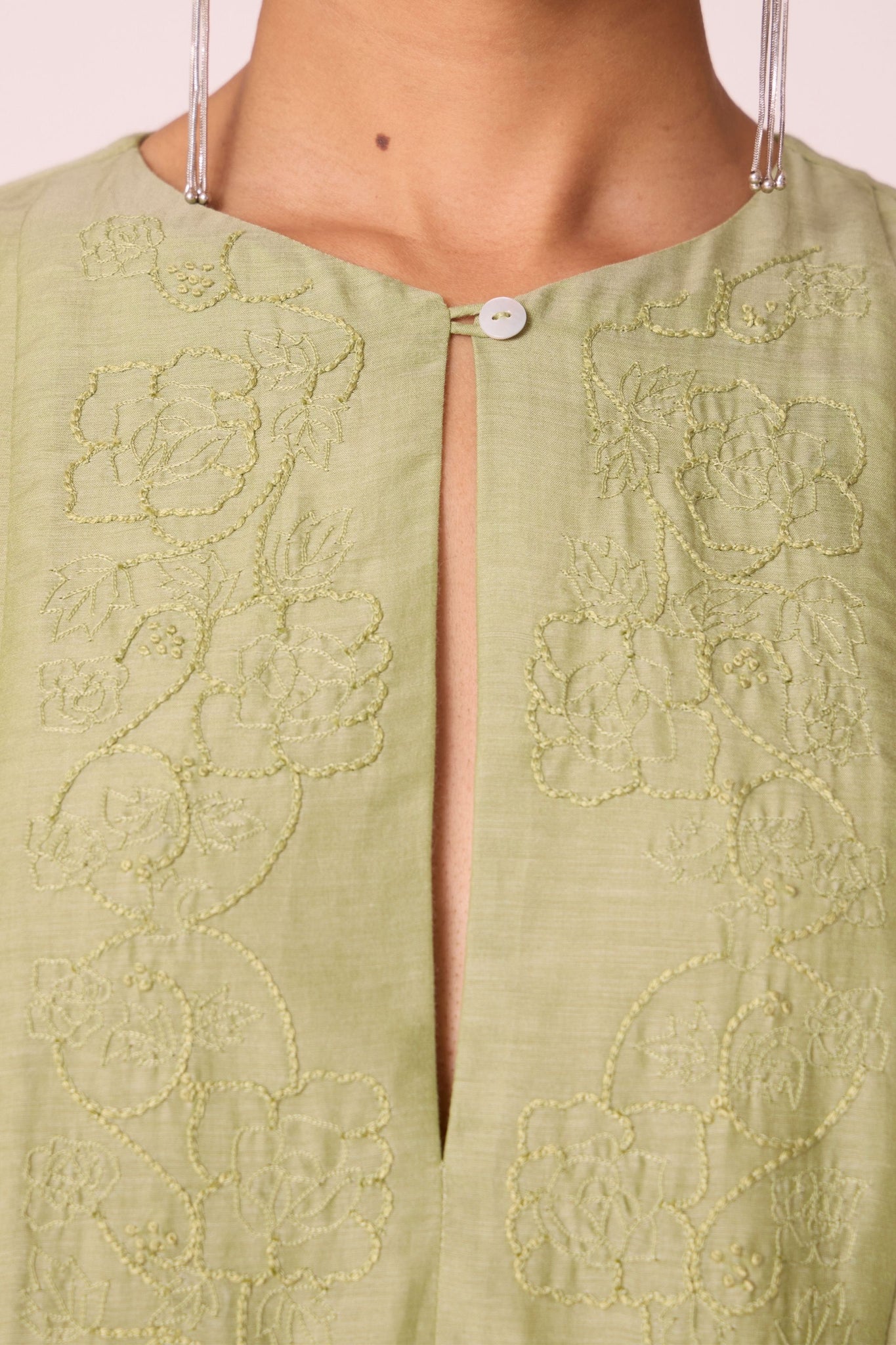 Green silk-cotton dress with hand-embroidered keyhole neckline, drop sleeves, full lining, and in-seam pockets.