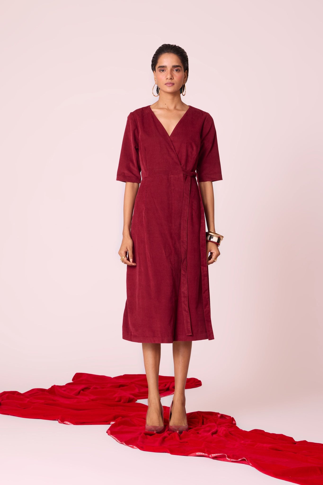 Cherry needlecord wrap dress with elbow-length sleeves, self-tie waist, and in-seam pockets.
