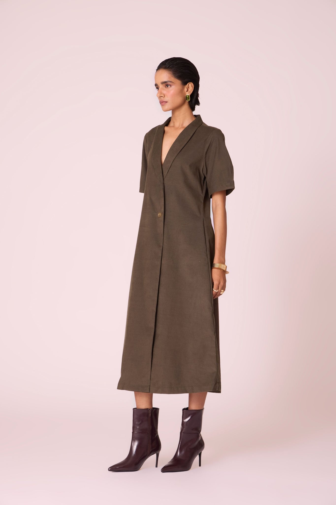 Olive needlecord structured wrap dress with double button fastening, shawl collar, sleeve box pleats, and in-seam pockets.
