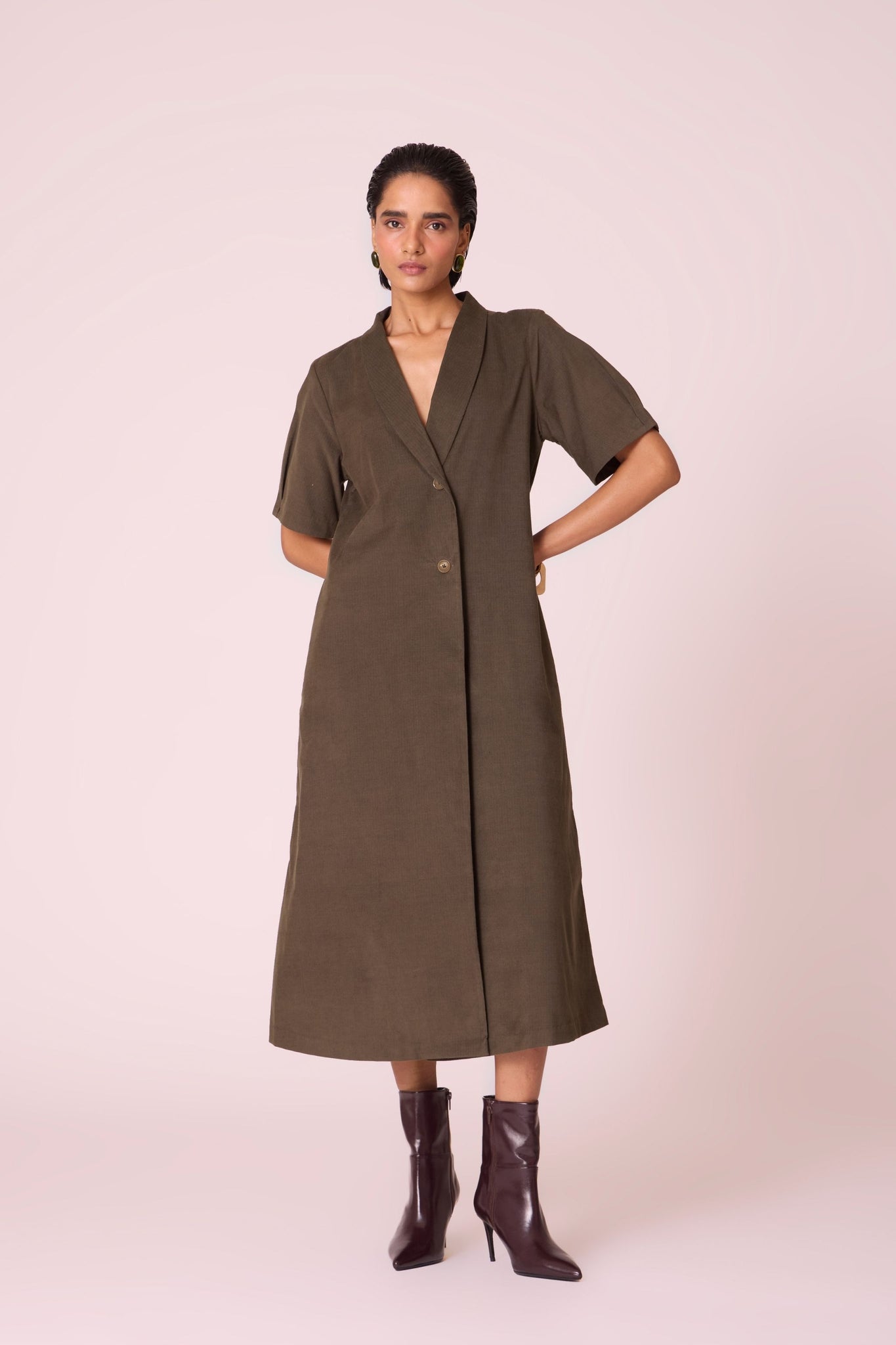 Olive needlecord structured wrap dress with double button fastening, shawl collar, sleeve box pleats, and in-seam pockets.