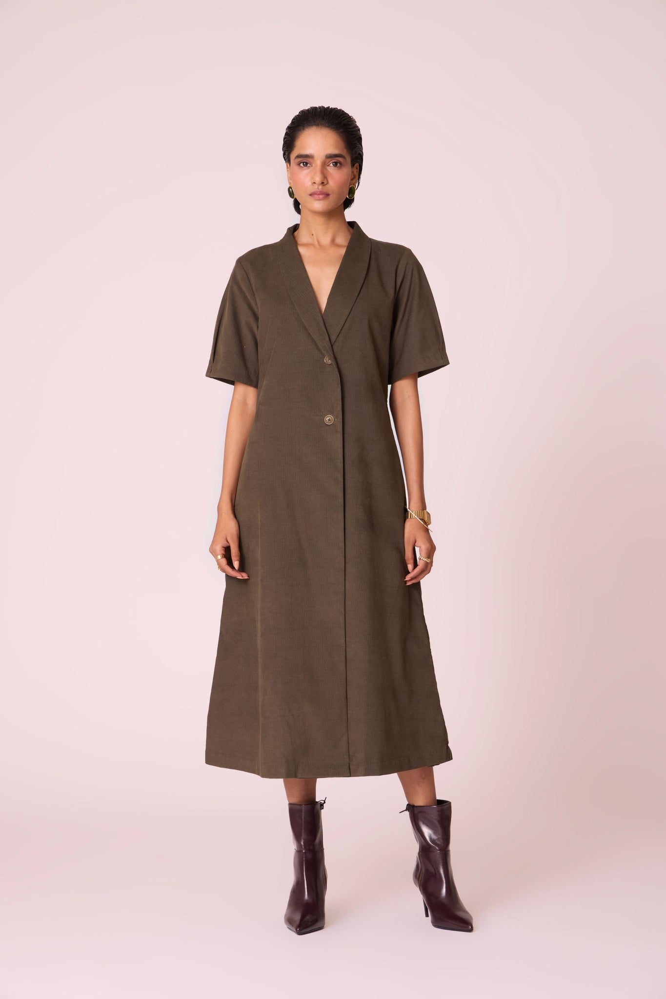 Olive needlecord structured wrap dress with double button fastening, shawl collar, sleeve box pleats, and in-seam pockets.