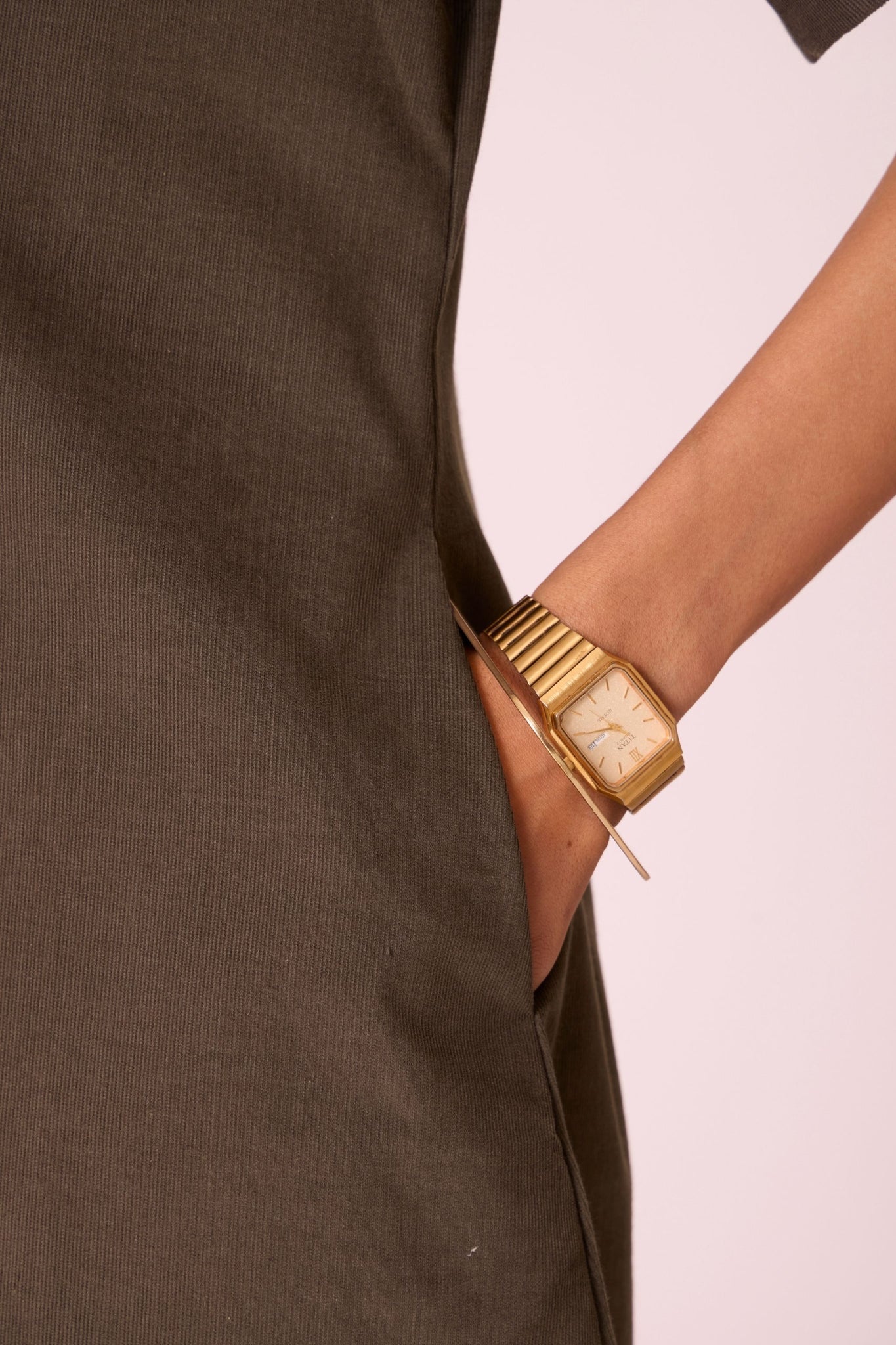 Olive needlecord structured wrap dress with double button fastening, shawl collar, sleeve box pleats, and in-seam pockets.