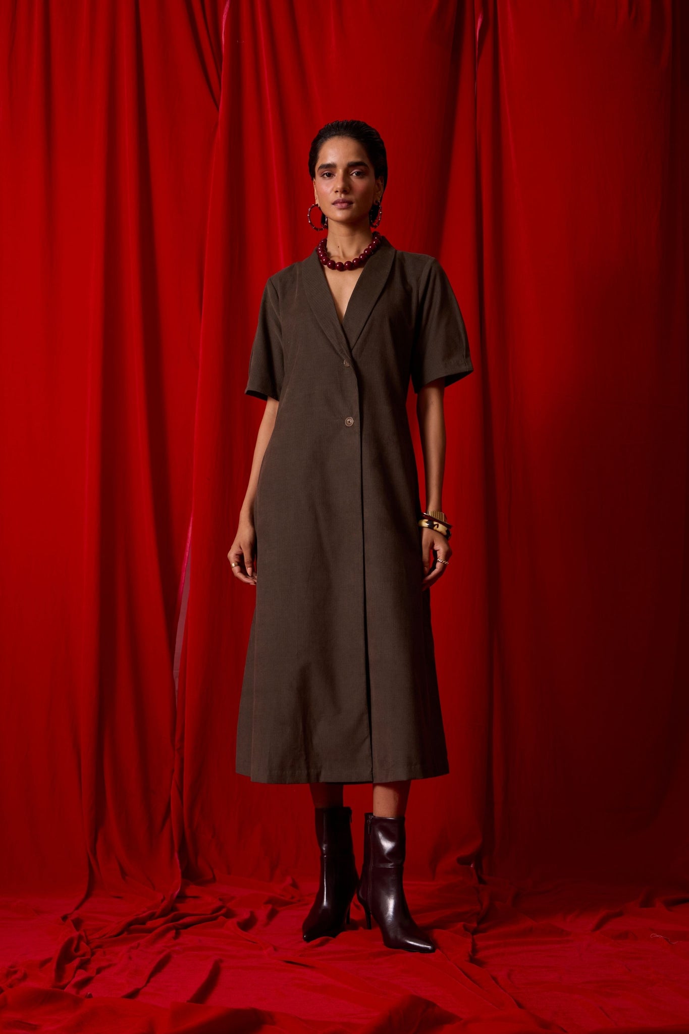Olive needlecord structured wrap dress with double button fastening, shawl collar, sleeve box pleats, and in-seam pockets.