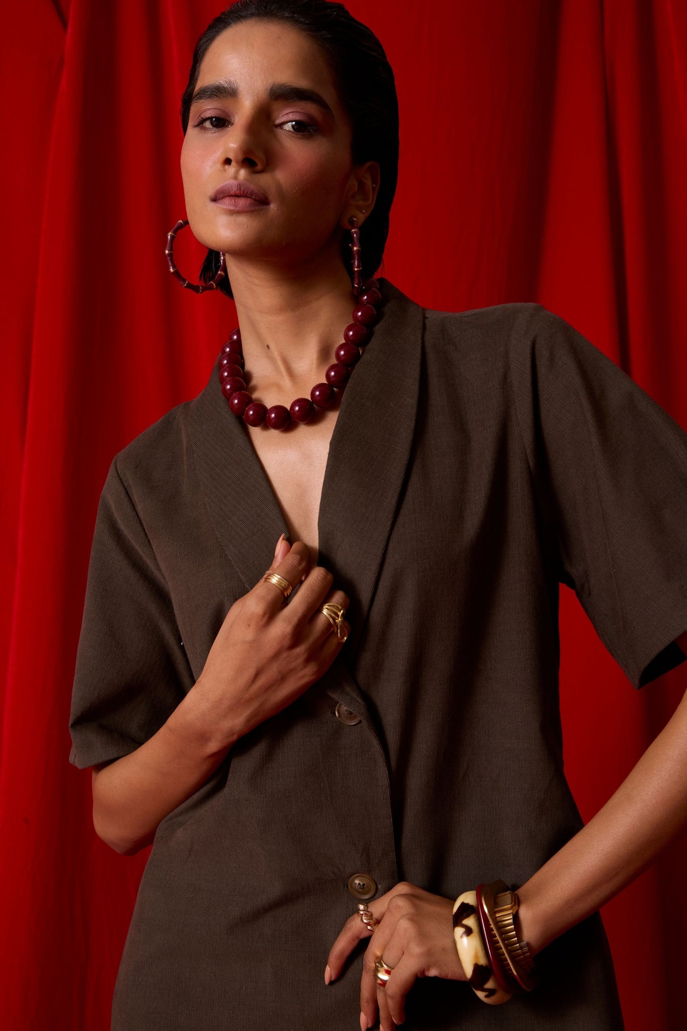 Olive needlecord structured wrap dress with double button fastening, shawl collar, sleeve box pleats, and in-seam pockets.