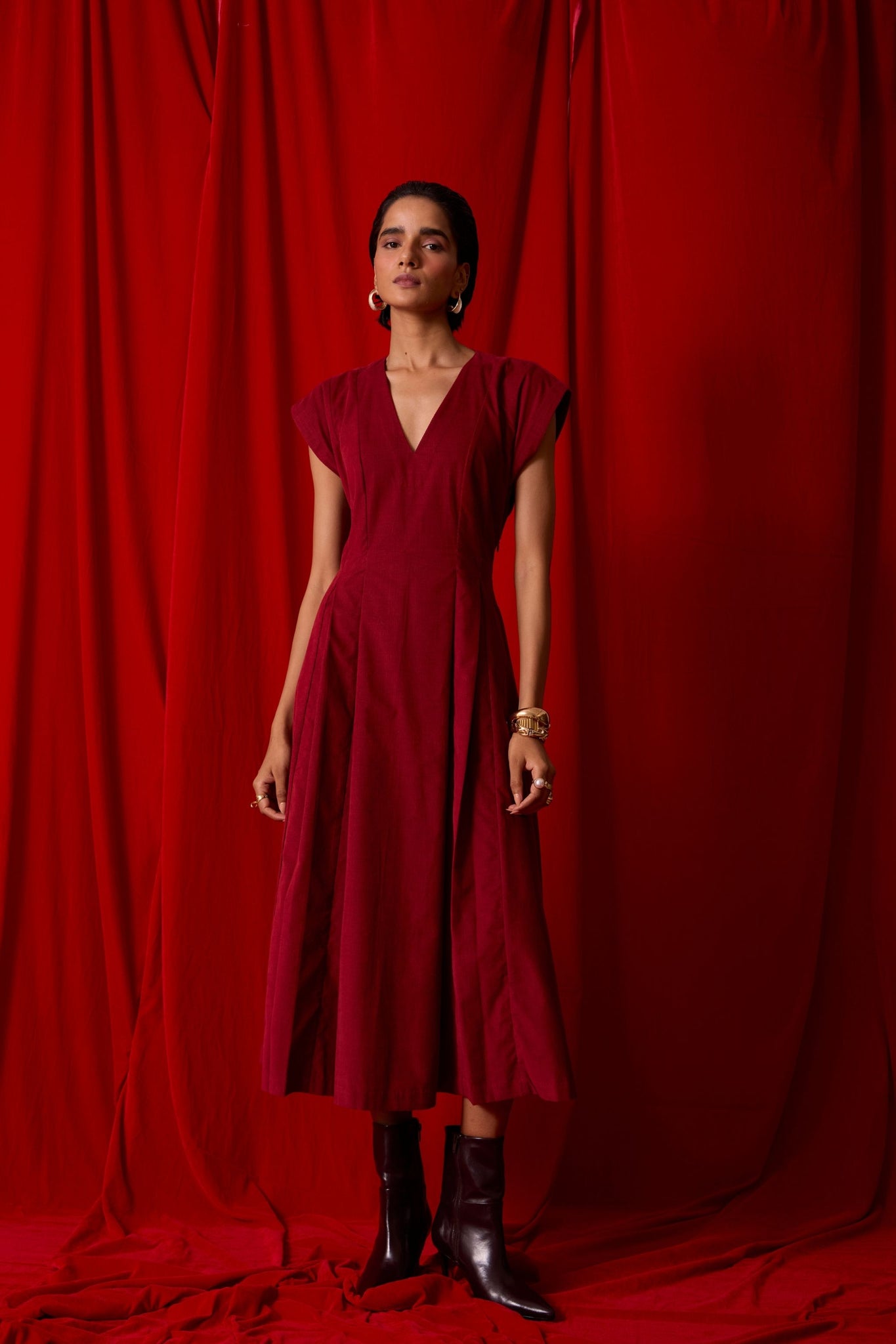 Rust needlecord panelled dress with box pleats, structured drop shoulder, V-neckline, side zip, and in-seam pockets.