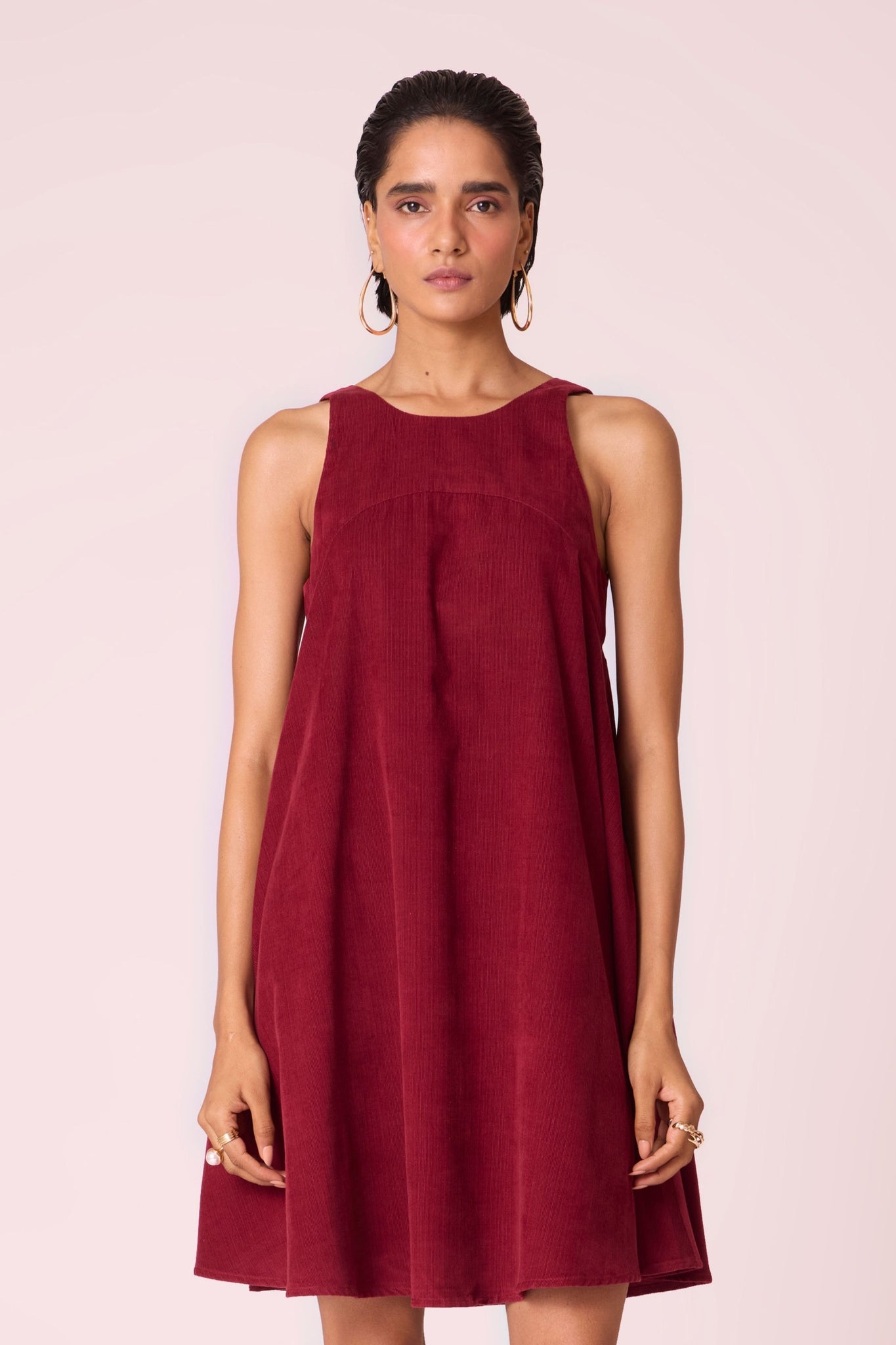 Cherry needlecord tent dress with incut shoulder, low scoop back, and in-seam pockets.
