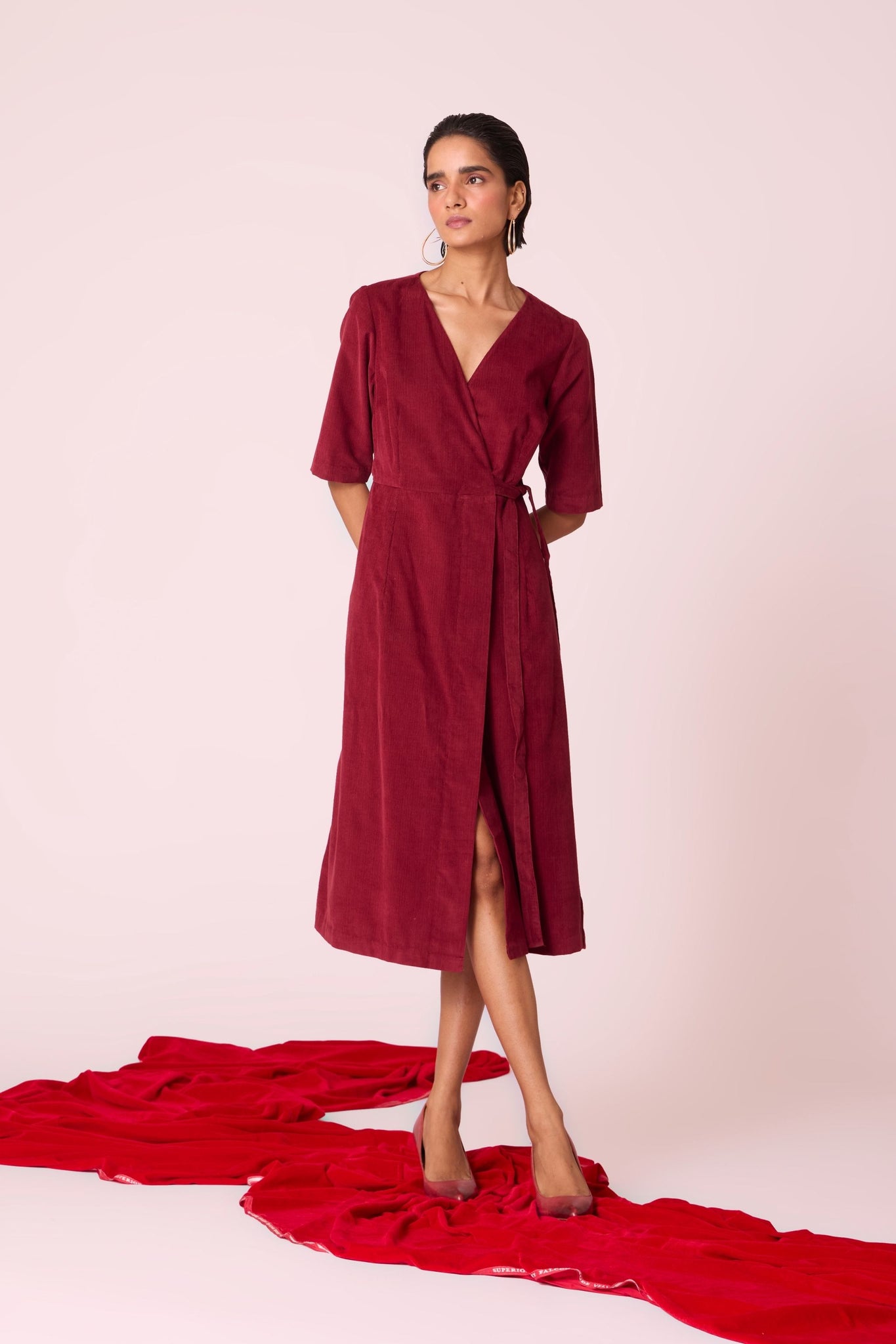 Cherry needlecord wrap dress with elbow-length sleeves, self-tie waist, and in-seam pockets.
