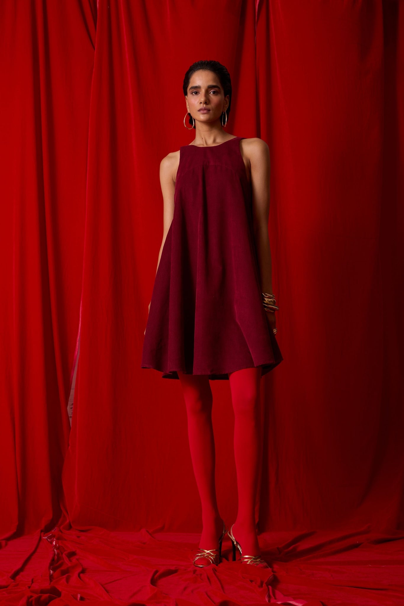 Cherry needlecord tent dress with incut shoulder, low scoop back, and in-seam pockets.
