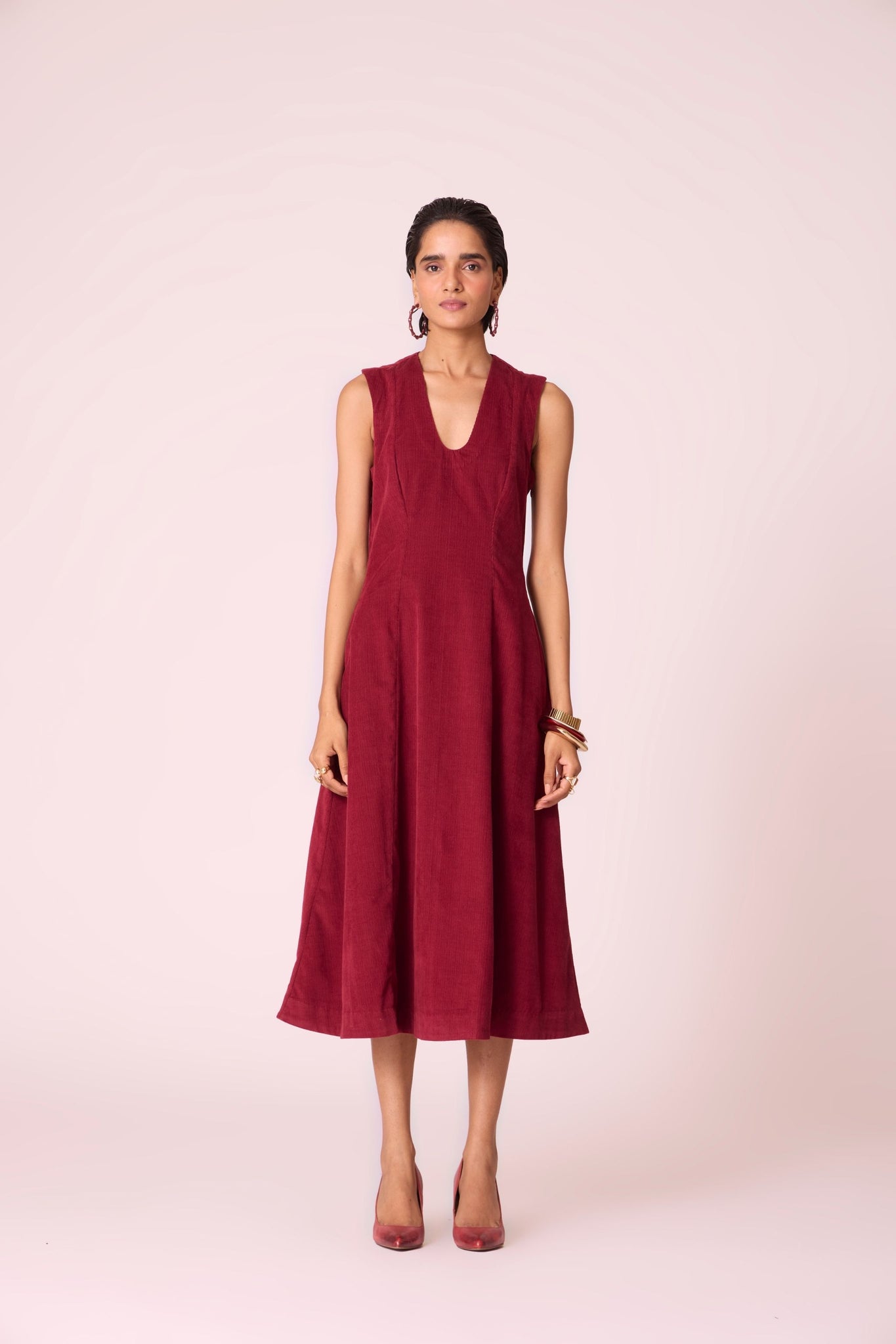 Cherry needlecord fit-and-flare midi dress with soft V-neckline, panel detailing, side zip, and in-seam pockets.
