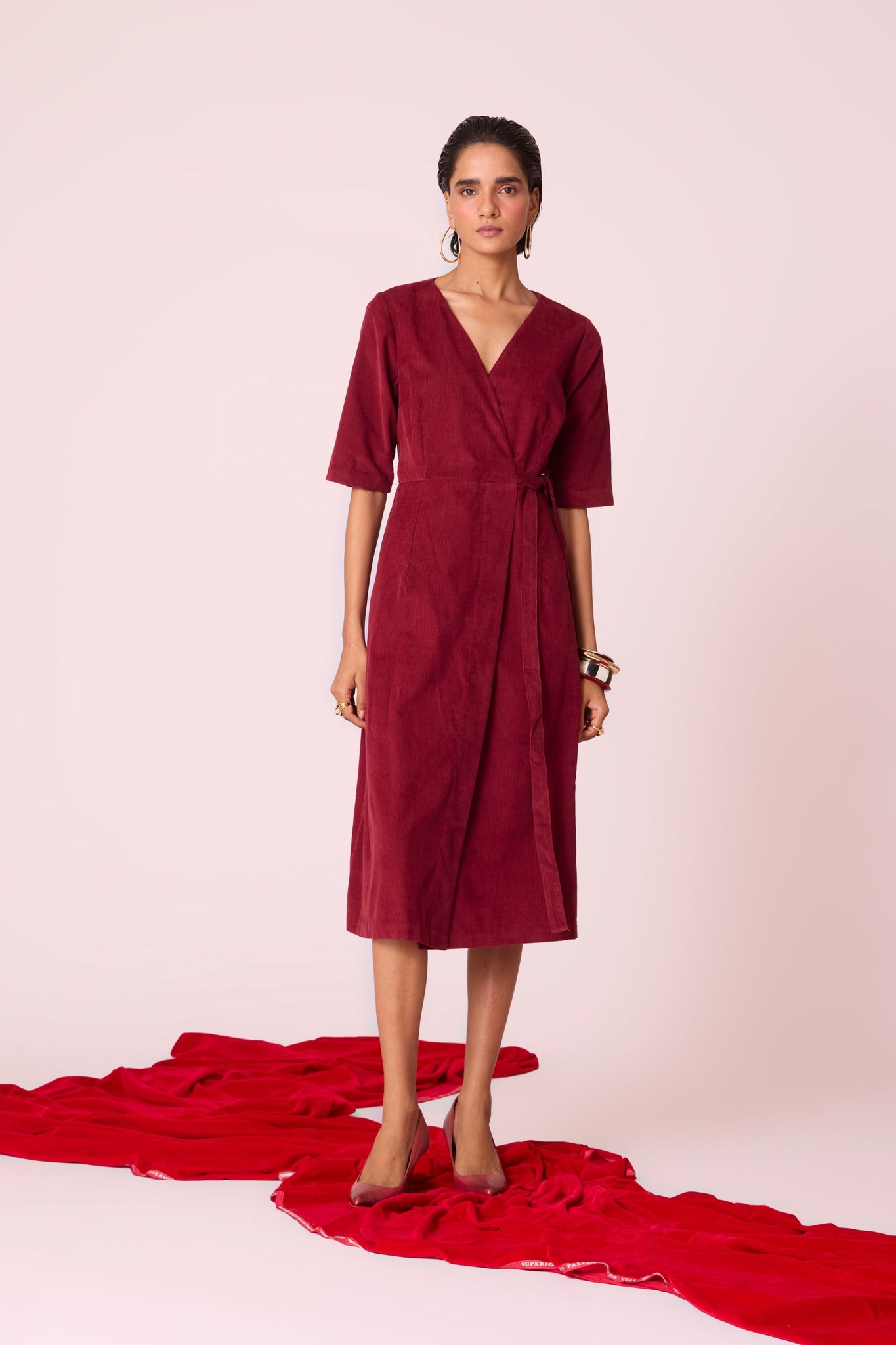 Cherry needlecord wrap dress with elbow-length sleeves, self-tie waist, and in-seam pockets.
