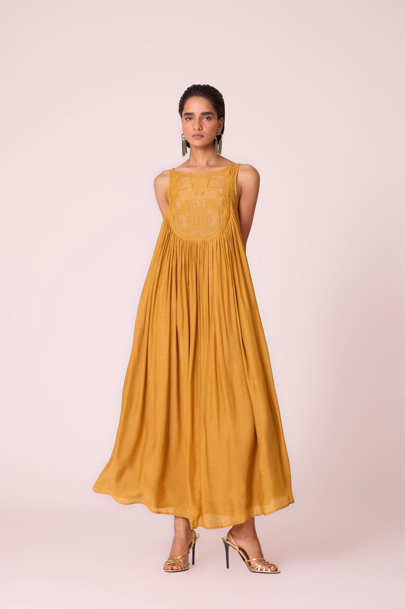 Yellow cupro maxi dress with hand-embroidered yoke, low scoop back with elastic strap, full lining, and light waist gathers.
