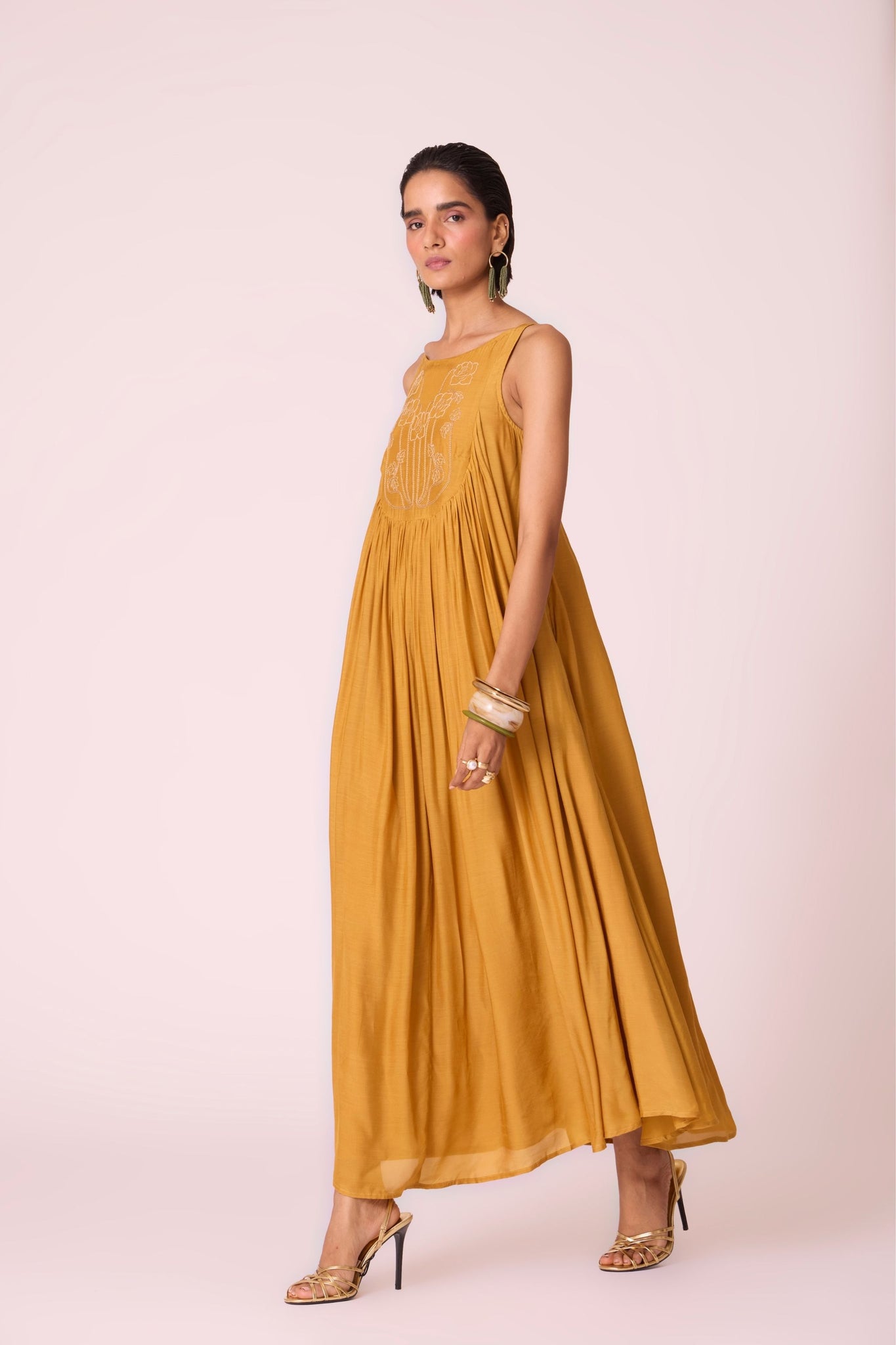 Yellow cupro maxi dress with hand-embroidered yoke, low scoop back with elastic strap, full lining, and light waist gathers.
