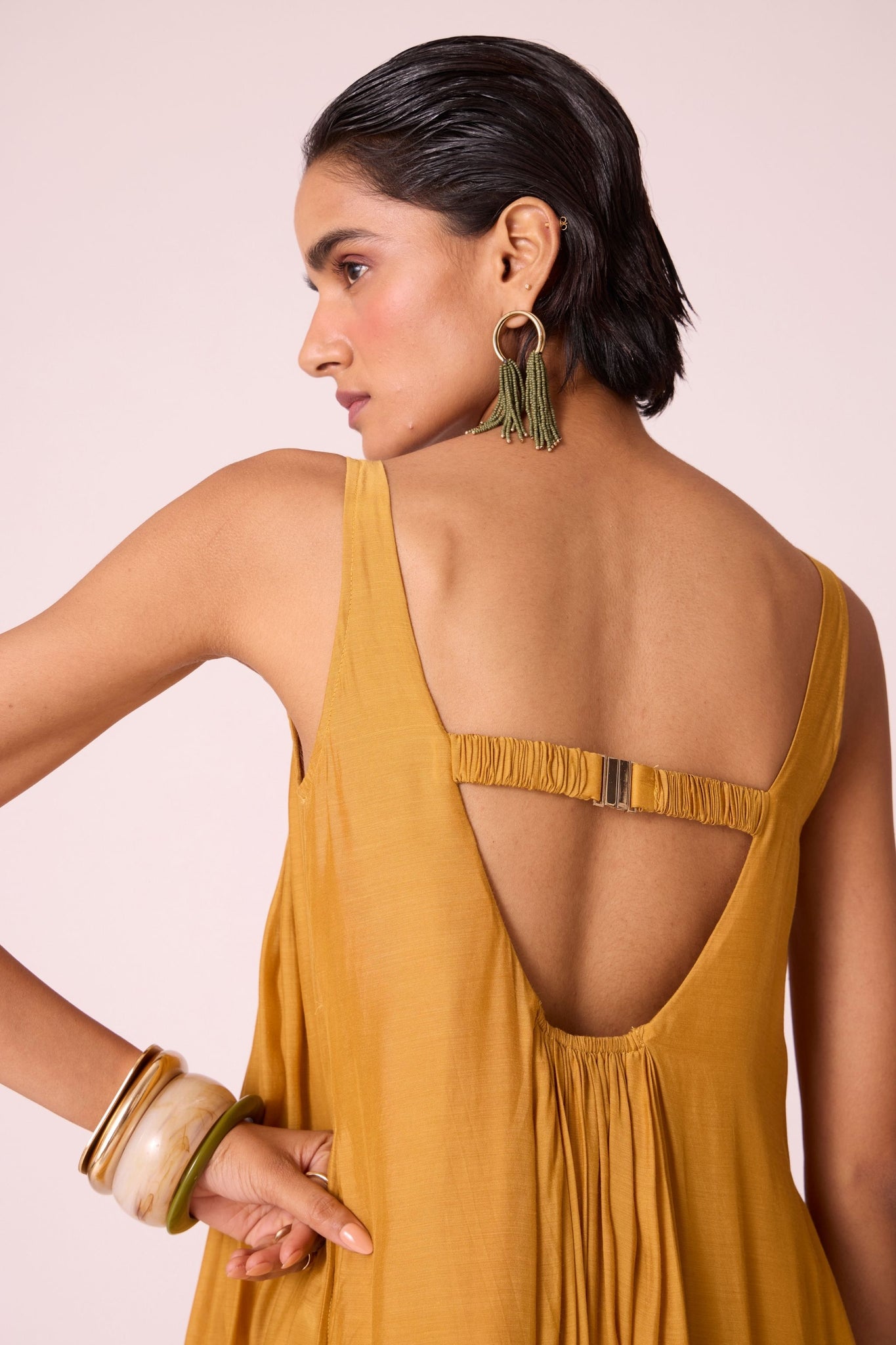 Yellow cupro maxi dress with hand-embroidered yoke, low scoop back with elastic strap, full lining, and light waist gathers.
