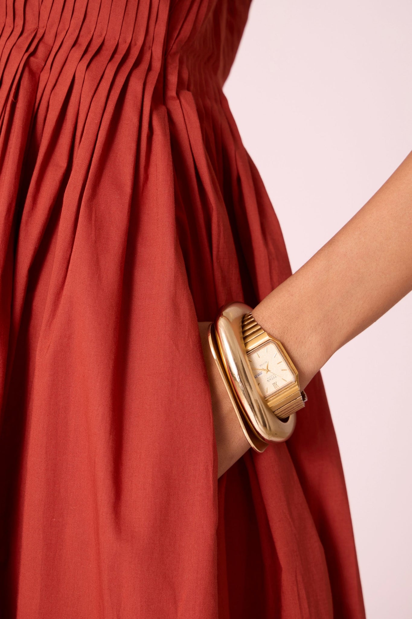 Rust pleated dress in organic cotton voile with a square neckline, thick straps, and a fully lined flared silhouette.
