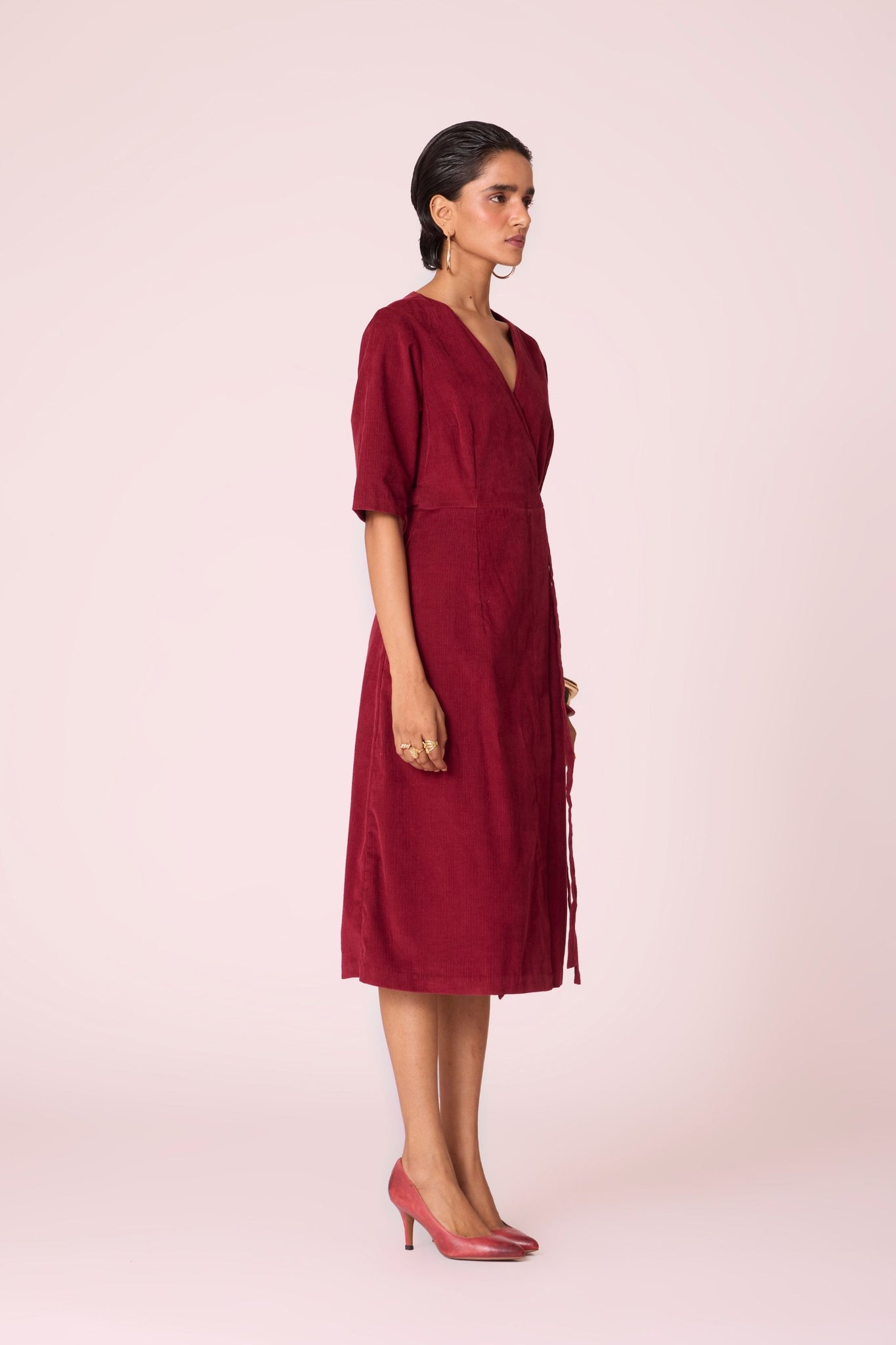 Cherry needlecord wrap dress with elbow-length sleeves, self-tie waist, and in-seam pockets.
