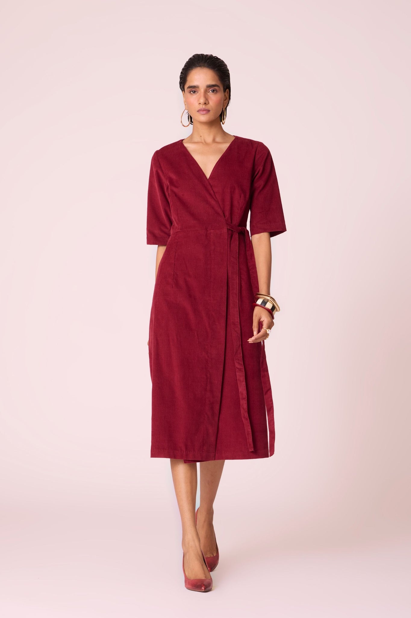 Cherry needlecord wrap dress with elbow-length sleeves, self-tie waist, and in-seam pockets.
