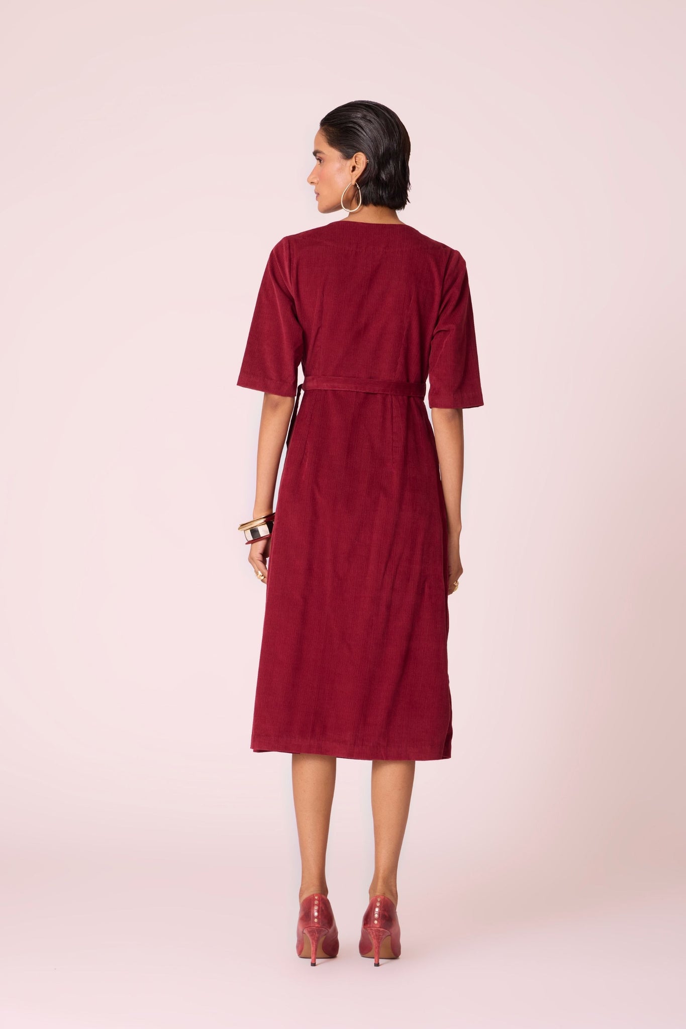 Cherry needlecord wrap dress with elbow-length sleeves, self-tie waist, and in-seam pockets.

